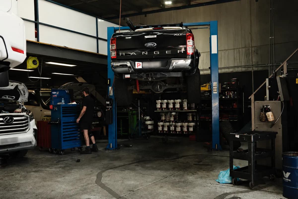 A Rev'd Up mechanic servicing a Ford Ranger raised on the hoist